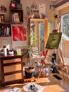 an artist's easel in the corner of a room filled with art supplies