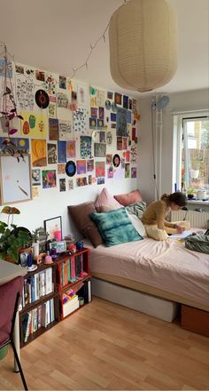 a bed room with a neatly made bed and lots of pictures on the wall