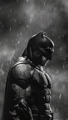 black and white photo of batman standing in the rain