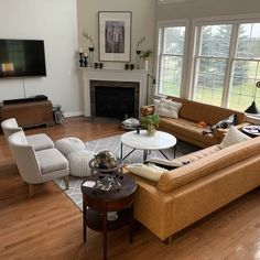 a living room filled with furniture and a flat screen tv mounted on the wall above a fire place