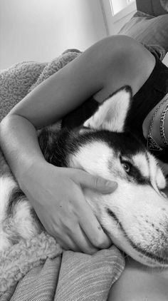 a black and white photo of a woman hugging her dog