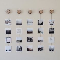 there are many pictures hanging on the wall with clothes pins attached to them and some wood circles