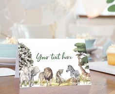 a card with animals on it sitting on a table next to a plate of cupcakes