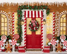 a red door decorated with candy canes and christmas decorations