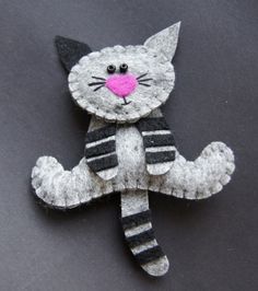 a cat brooch with a pink nose and black stripes