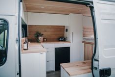 the interior of a camper van with wood paneling on the walls and floor