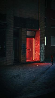 a red door is lit up in the dark