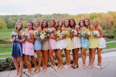 a group of women standing next to each other holding bouquets