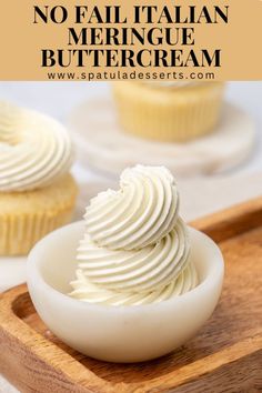 some cupcakes with white frosting in a bowl on a wooden tray and the words, no fail italian meringue buttercream