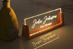 a light up bottle next to a sign that reads john johnson sales manager