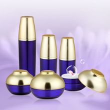 an assortment of blue and gold containers on a purple background