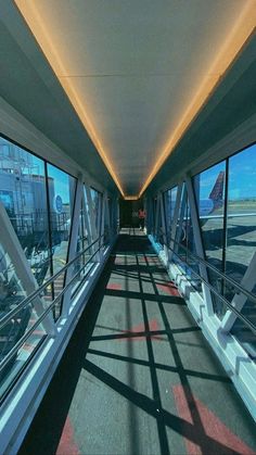 the inside of an airport terminal looking out at the tarmac and walkways that lead up to it