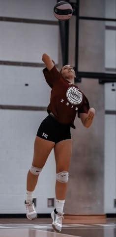 a female volleyball player jumping up to hit the ball