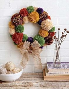 a wreath is hanging on the wall next to some yarn balls