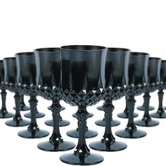 there are many black wine glasses lined up together