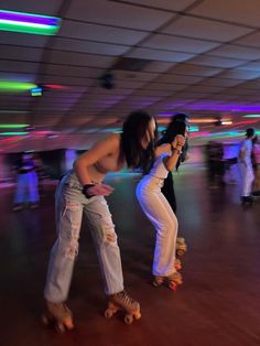 two women on roller skates in a large room