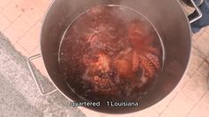 a large metal pot filled with food on top of a tile floor next to a person