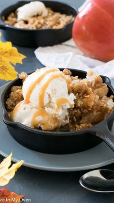 an apple crisp with ice cream in a cast iron skillet