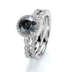 an engagement ring set with a black diamond in the center and white diamonds around it