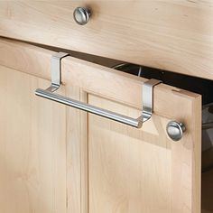 an open drawer in a wooden cabinet with metal handles and pullout bars on the bottom