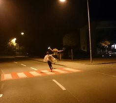 a person doing tricks on the street at night