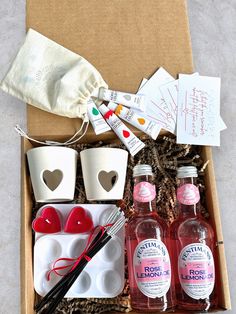 an open box containing two bottles of liquid and some other items to make valentine's day gifts