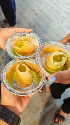 three people holding up small plates with food in them