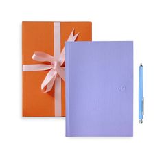 two notebooks with ribbons and a pen on the front one has a blank notepad attached to it