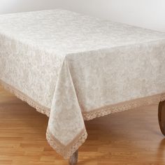 a white table cloth on top of a wooden chair in a room with hard wood floors