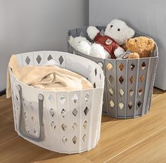 two baskets with teddy bears in them sitting on the floor next to each other,