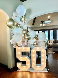 a 50th birthday decoration with balloons and lights