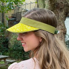 Boo That have reimagined the sun visor into fashionable, luxurious statement headwear. They are lightweight and soft to wear and to handle.  Visors are made one at a time, by hand, in my London millinery studio in a range of carefully curated fabrics.  Size Medium fits approximately 53-59cm head size. Chartreuse yellow graphic print with contrast sage green linen. They were developed originally for a customer who wanted something prettier than a sports visor to protect her skin when she was havi Spring Brimmed Visor With Upf 50+, Wide Brim Visor With Upf 50+ For Spring, Spring Wide Brim Visor With Upf 50+, Spring Upf 50+ Brimmed Visor, Spring Wide Brim Visor, Spring Wide Brim Hat With Adjustable Fit, Spring Sun Visor With Uv Protection, Spring Outdoor Visor, Casual Summer Visor With Short Brim