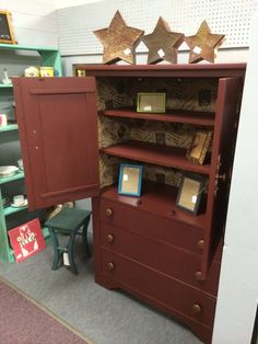 an open bookcase with three stars on top