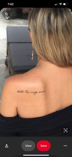 the back of a woman's shoulder with an inscription on it that reads, and she