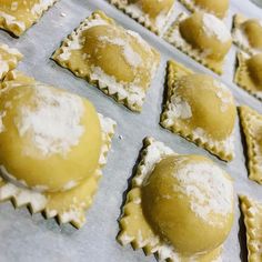 several pastries covered in powdered sugar sit on a baking sheet, ready to be baked