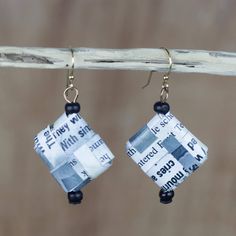 the earrings are made out of newspaper strips and beaded with black glass beads on them