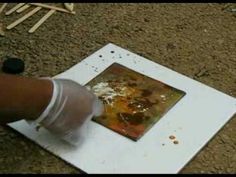 someone is holding something in their hand while they are working on an art project with acrylic paint