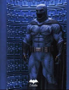 the batman statue is standing in front of a blue background with an open door and text that