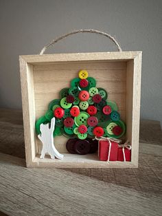 a small wooden box with buttons in the shape of a christmas tree on top of a table