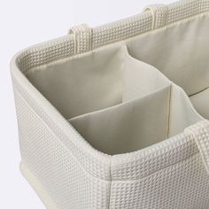 the bottom section of a white wicker basket with three compartments and two dividers