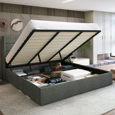 a bed with an open storage compartment underneath it in a room next to a window