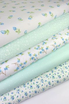 four different types of fabric with blue flowers on them, all in pastel colors