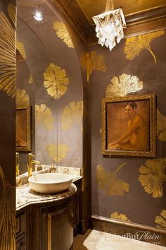 a bathroom with gold leaf wallpaper and a sink