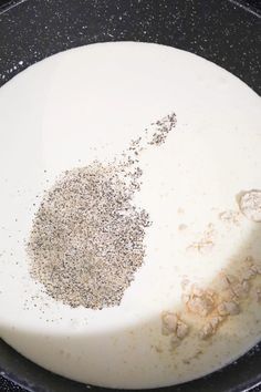 a pan filled with food cooking on top of a stove burner and seasoning