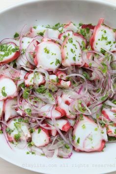 a white bowl filled with onions and radishes