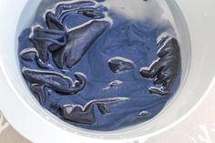 a white bowl filled with blue liquid on top of a table