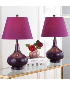 two purple lamps on a table with a red rose