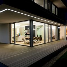 a house that is lit up at night with lights on the outside and in the inside