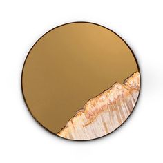 a round mirror with an image of a mountain in the middle and gold paint on it