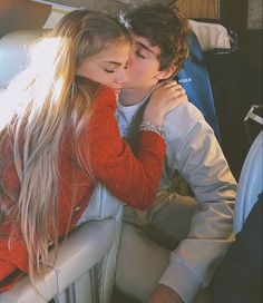 a young man and woman kissing in the back seat of a car